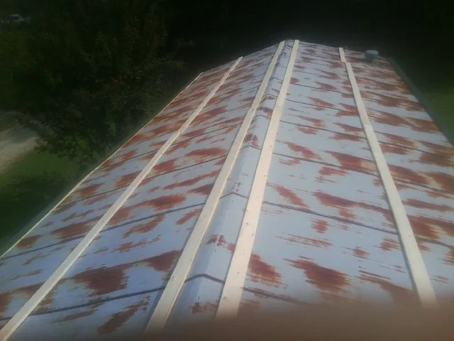 Rusted metal roof panels with new wood purlins before replacement — Storm Damage Roof Repair in Woodward by Roofing Brothers